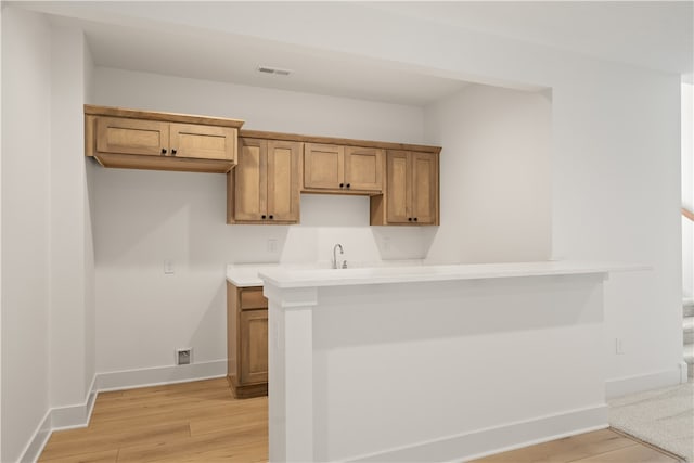 kitchen featuring sink, light hardwood / wood-style floors, and kitchen peninsula