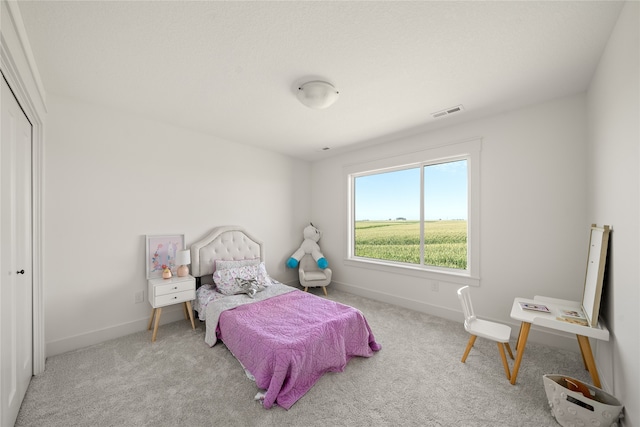 bedroom featuring light colored carpet and a closet