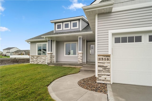 entrance to property featuring a garage and a lawn