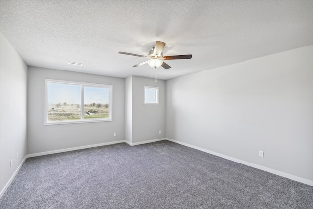 carpeted empty room featuring ceiling fan and a textured ceiling