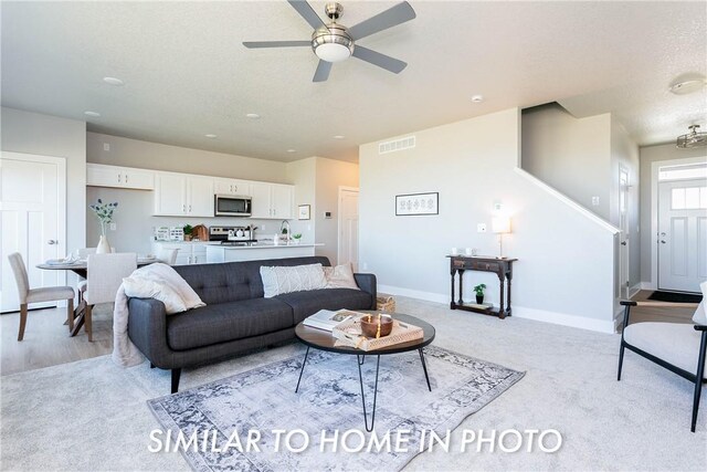 carpeted living room featuring sink and ceiling fan