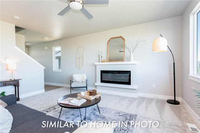 carpeted living room featuring ceiling fan