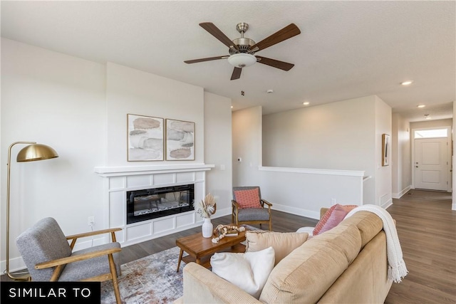 living room featuring baseboards, a glass covered fireplace, ceiling fan, wood finished floors, and recessed lighting