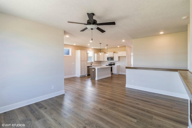 unfurnished living room with dark wood-style flooring, recessed lighting, ceiling fan, a textured ceiling, and baseboards