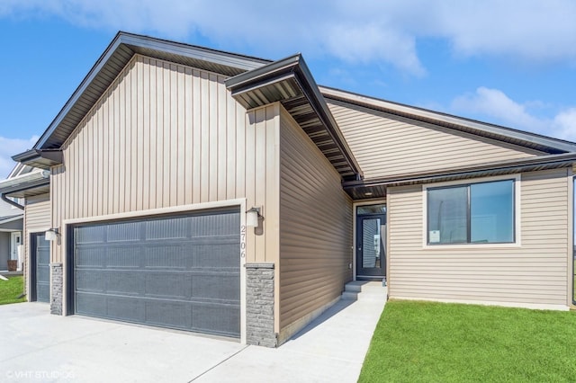 view of front of home featuring driveway, board and batten siding, and a front yard