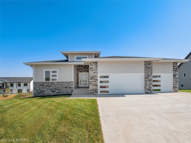 prairie-style home with a front lawn and a garage