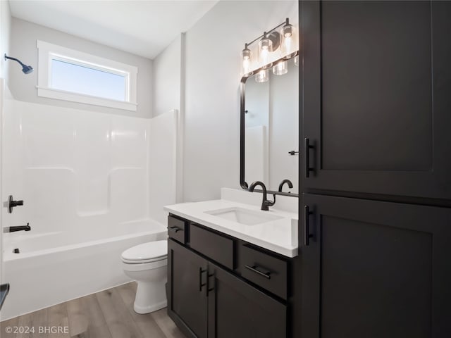 full bathroom featuring toilet, bathing tub / shower combination, vanity, and hardwood / wood-style flooring