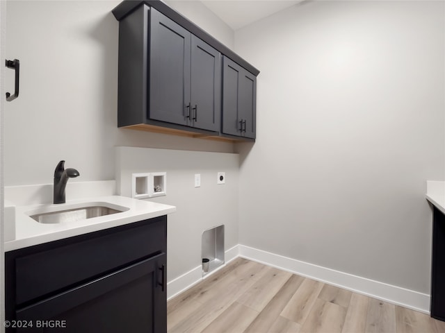 laundry area featuring hookup for an electric dryer, cabinets, sink, light hardwood / wood-style flooring, and hookup for a washing machine