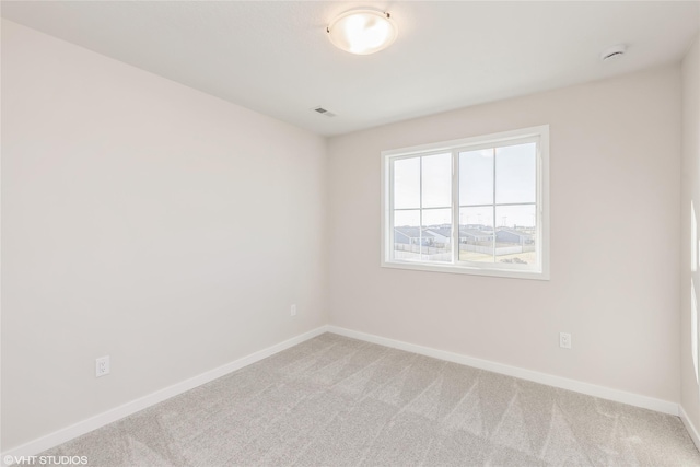 spare room featuring light carpet