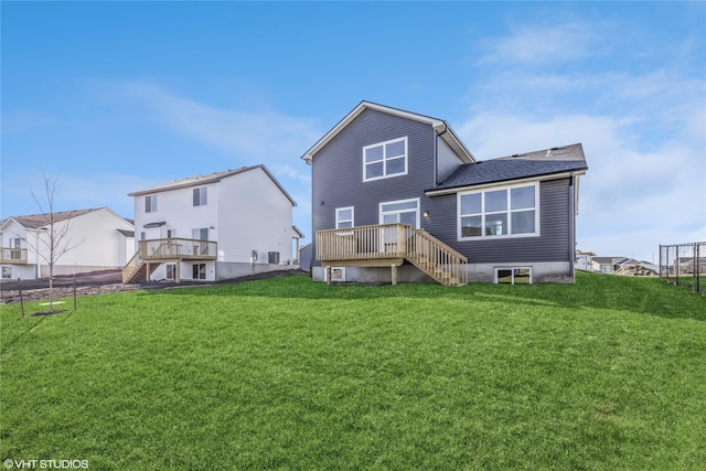 rear view of house with a deck and a yard