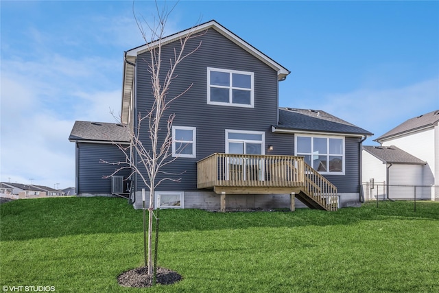 back of house featuring a lawn and a deck