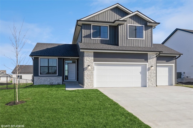 view of front of house with a garage, a front lawn, and central air condition unit