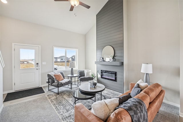 carpeted living room with a large fireplace, high vaulted ceiling, and ceiling fan