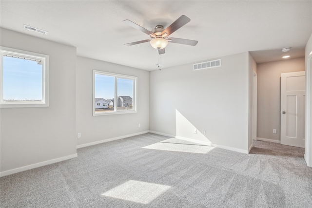 empty room with ceiling fan and light colored carpet