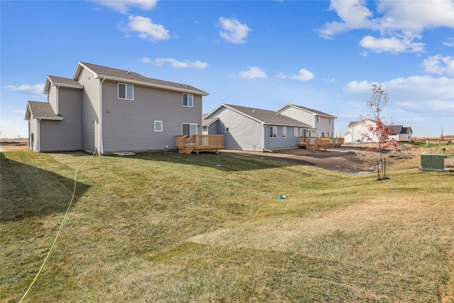 rear view of house with a yard and a wooden deck