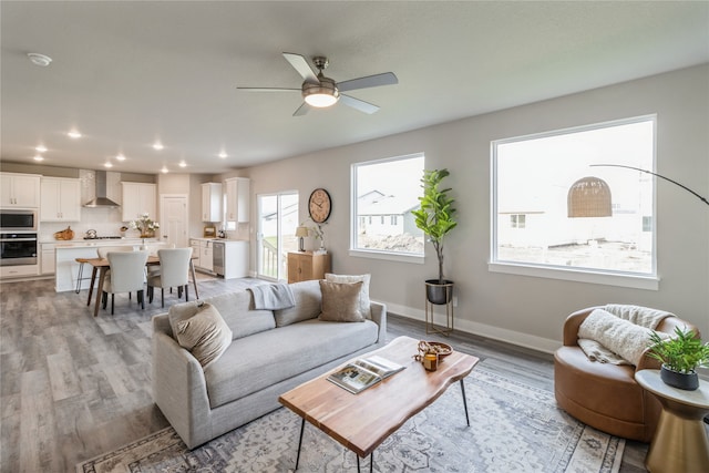 living room with light wood-type flooring and ceiling fan