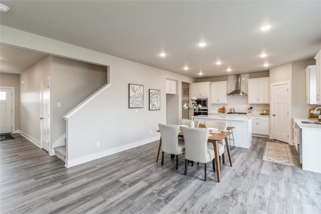 dining space with sink and light wood-type flooring