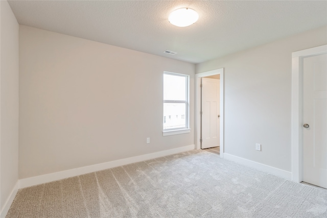 carpeted spare room with a textured ceiling