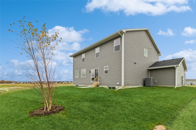 rear view of property featuring cooling unit and a lawn