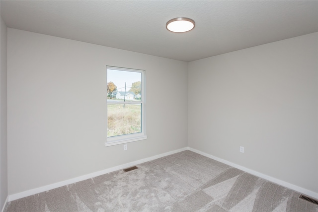 unfurnished room with a textured ceiling and carpet floors