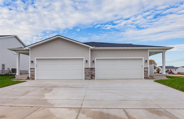 ranch-style house featuring central air condition unit and a garage