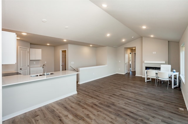 kitchen featuring lofted ceiling, white cabinetry, sink, and dark hardwood / wood-style flooring