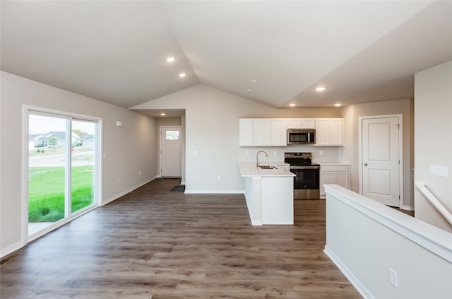 kitchen featuring white cabinets, vaulted ceiling, dark wood-type flooring, sink, and stainless steel appliances