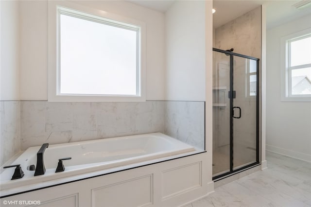 bathroom with a wealth of natural light and separate shower and tub