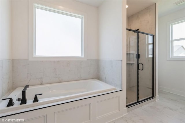 bathroom with plenty of natural light and separate shower and tub