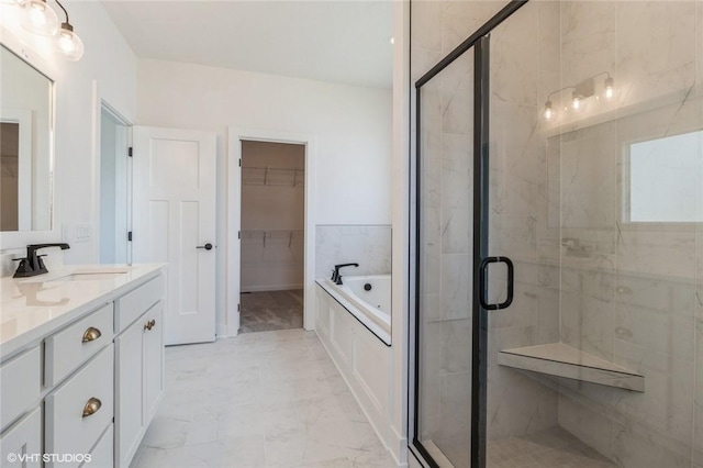 bathroom featuring vanity and independent shower and bath