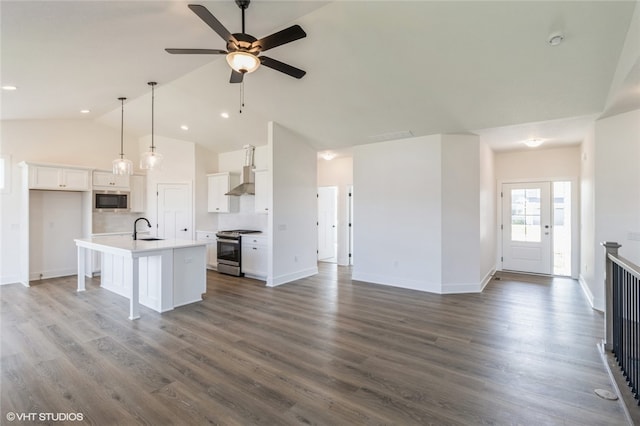 kitchen featuring sink, white cabinetry, stainless steel appliances, lofted ceiling, and a kitchen island with sink