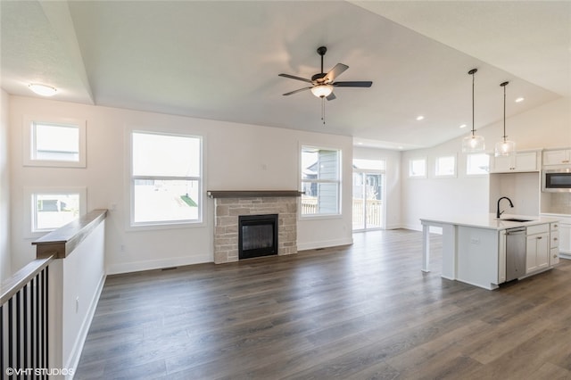 unfurnished living room with lofted ceiling, a healthy amount of sunlight, sink, and dark hardwood / wood-style flooring