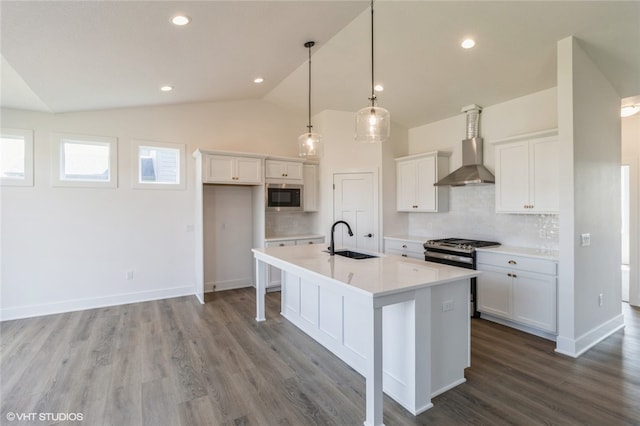 kitchen featuring sink, white cabinetry, stainless steel appliances, wall chimney exhaust hood, and lofted ceiling