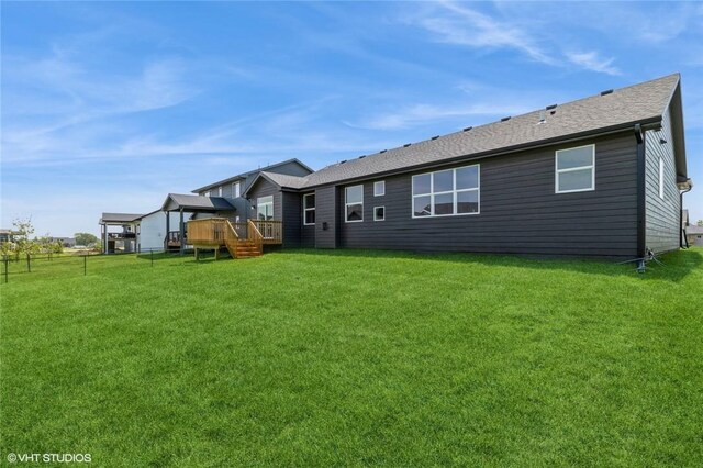 back of house with a deck and a lawn