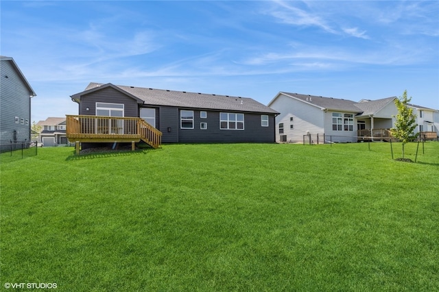 back of house with a deck and a lawn