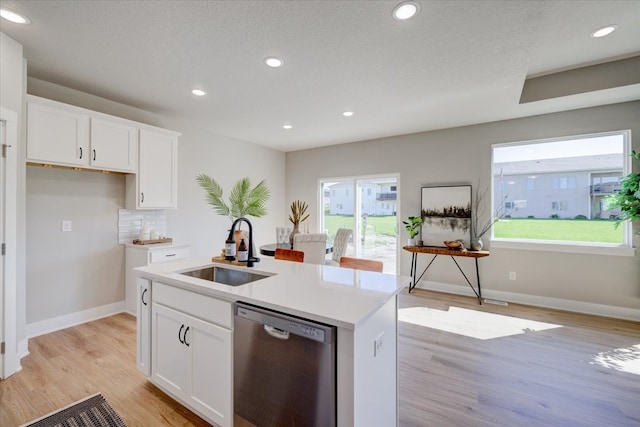 kitchen with a kitchen island with sink, sink, light hardwood / wood-style flooring, dishwasher, and white cabinetry