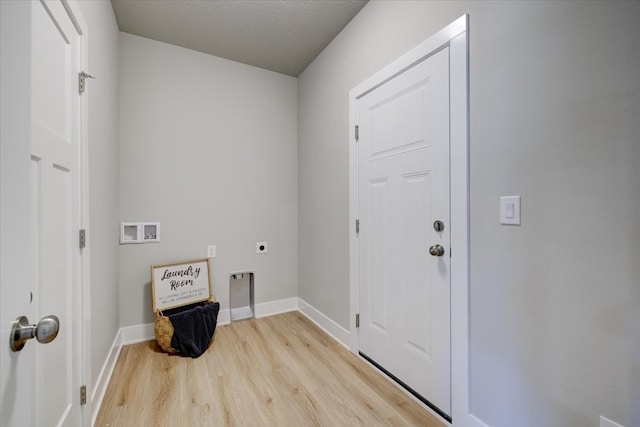 laundry area with hookup for an electric dryer, light wood-type flooring, a textured ceiling, and washer hookup