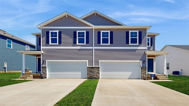 view of front facade featuring a garage, concrete driveway, stone siding, and central AC unit