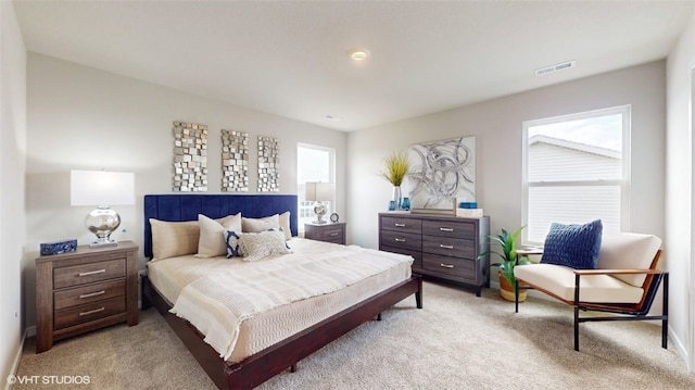 bedroom featuring visible vents and light colored carpet