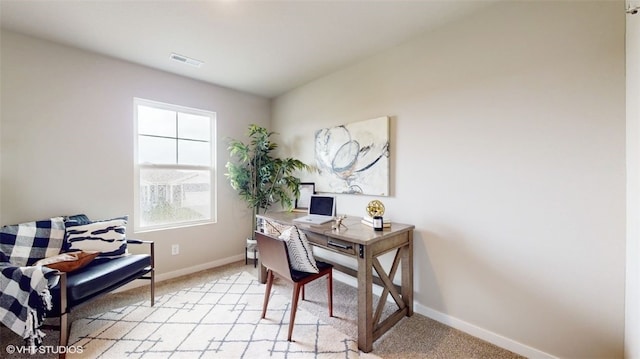 office space featuring baseboards, visible vents, and light colored carpet