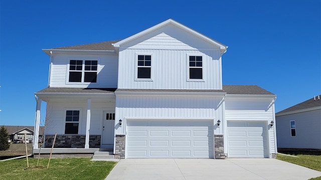 view of front of house with a porch, a garage, and a front lawn