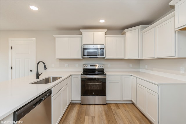 kitchen featuring sink, appliances with stainless steel finishes, and white cabinets