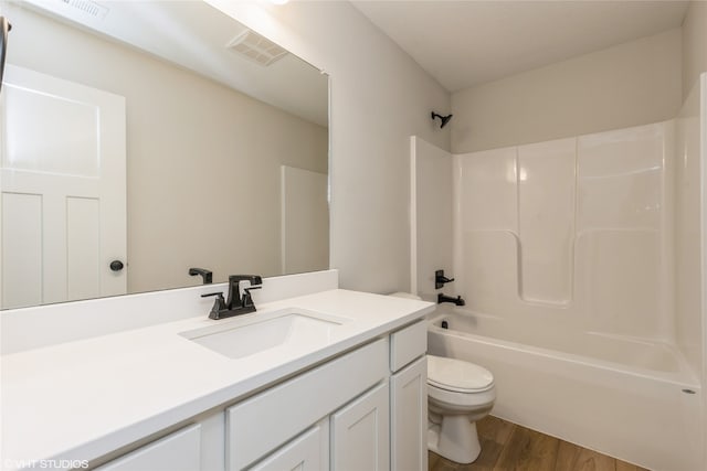 full bathroom with toilet, shower / tub combination, vanity, and wood-type flooring