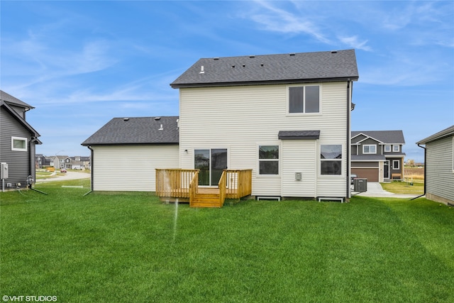 rear view of house featuring central air condition unit, a deck, a lawn, and a garage