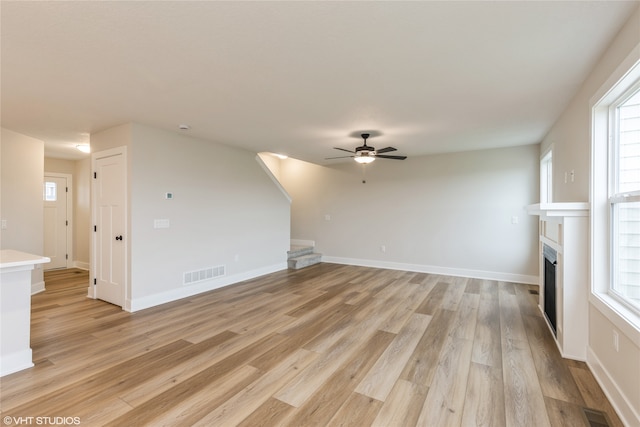 unfurnished living room with light hardwood / wood-style flooring and ceiling fan