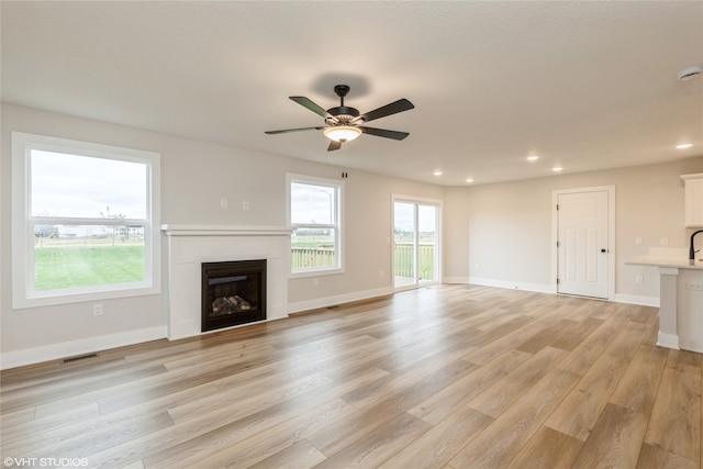 unfurnished living room featuring light hardwood / wood-style floors and ceiling fan