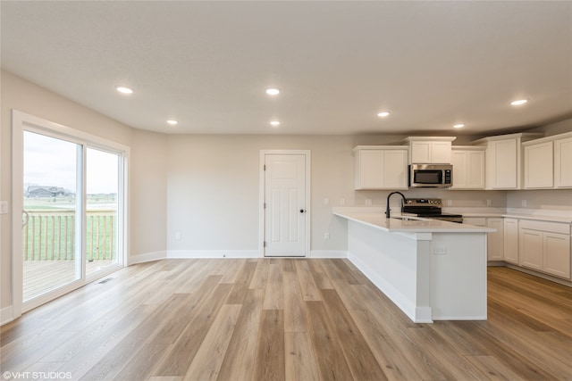 kitchen featuring sink, stainless steel appliances, light hardwood / wood-style flooring, and white cabinets