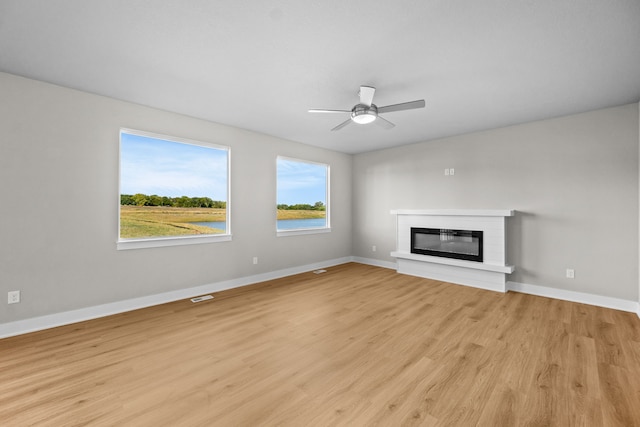 unfurnished living room with ceiling fan and light hardwood / wood-style flooring