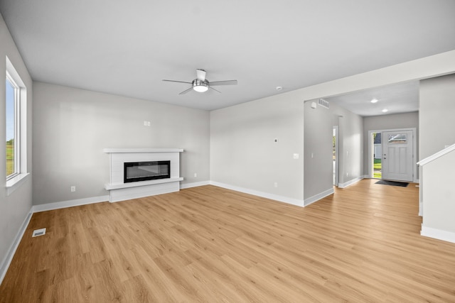 unfurnished living room with light hardwood / wood-style floors, plenty of natural light, and ceiling fan