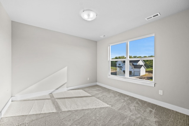 unfurnished room featuring light carpet